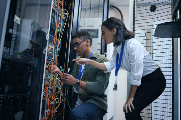 istock Cropped shot of two young computer programmers working together in a server room 1337471427