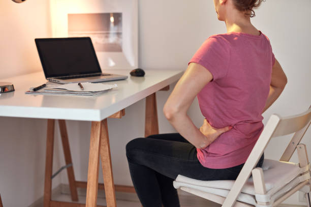 istock Woman working on a laptop at home and having problems with hips, back and stomack ache. 1337471593