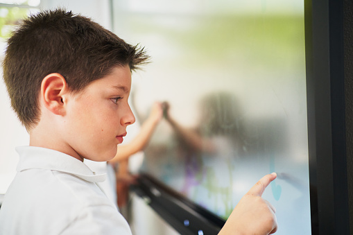 Young student kid interacting with digital blackboard
