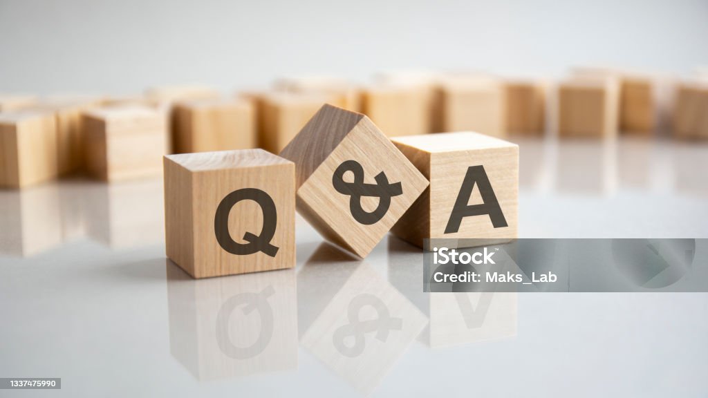 Q and A - question and answer shot form on wooden block Q and A - an abbreviation of wooden blocks with letters on a gray background. Reflection of the Q and A caption on the mirrored surface of the table. Selective focus. Q and A Stock Photo