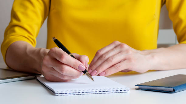 istock a woman writes down information with a pen in a diary 1337477178