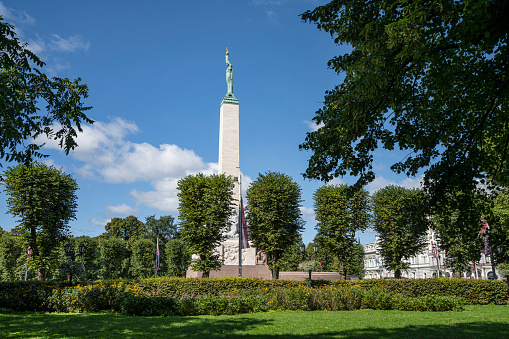 Riga, Latvia. August 2021. a view of the Freedom Monument from a park of the city center
