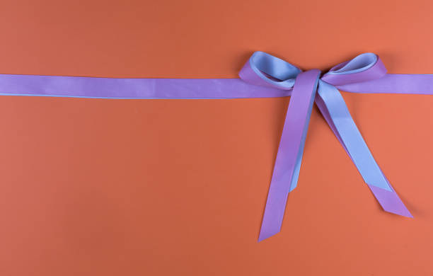 istock festive purple bow isolated on orange background 1337481041