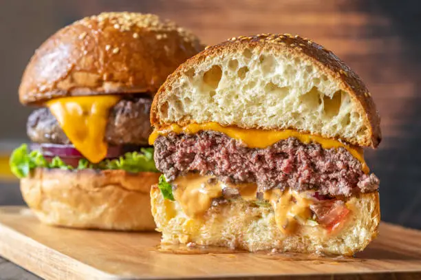 Two burgers on the wooden board close up