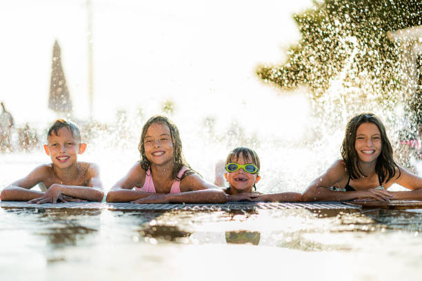 istock Cheerful kids having fun during summer day in the swimming pool 1337484864