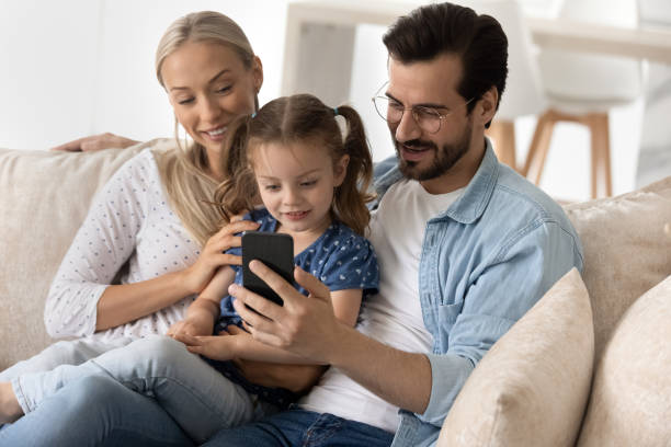 istock Happy parents and sweet gen Z kid using smartphone 1337484902