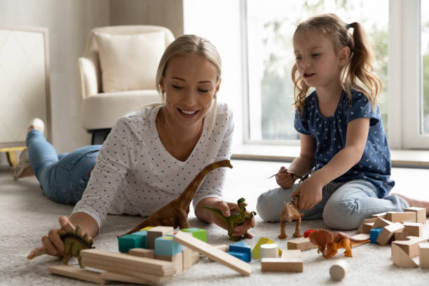 istock Happy positive mom and kid playing with dinosaurs 1337484910
