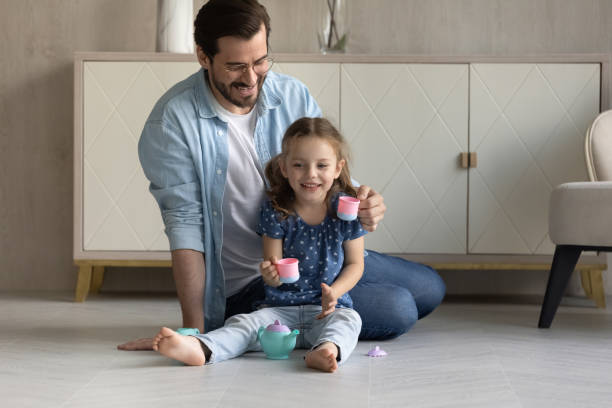 istock Happy dad and cute daughter girl drinking imaginary coffee 1337484926