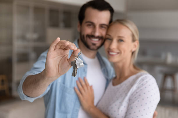 istock Happy millennial couple showing key from new house 1337485021