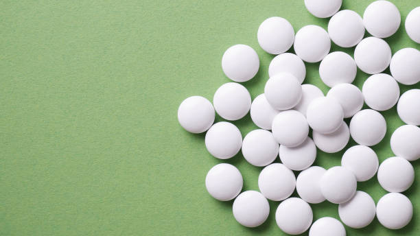 istock The pills are scattered on the table. Tablets on the green background. Medicinal tablets, capsules, pills. 1337486101