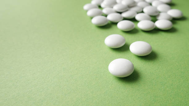 istock The pills are scattered on the table. Tablets on the green background. Medicinal tablets, capsules, pills. 1337486106