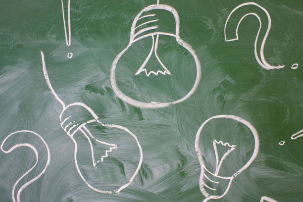 istock Electric lamps and question marks drawn on blackboard and a copy space 1337486147