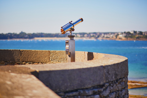 Touristic telescope on the fortress wall surrounding Saint-Malo Intra-Muros in Saint-Malo, Brittany, France