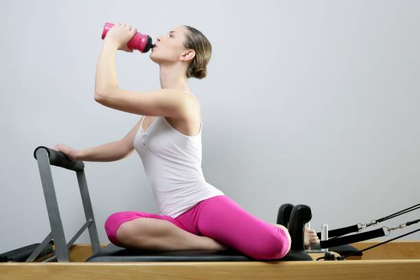 aerobic gym pilates frau ruhe trinkwasserflasche - exercising sensuality water bottle relaxation exercise stock-fotos und bilder