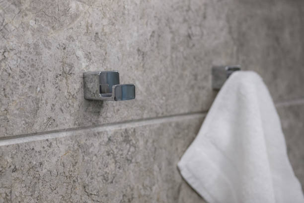 istock Clean white towel on a chrome hanger on a grey marble wall. 1337489438