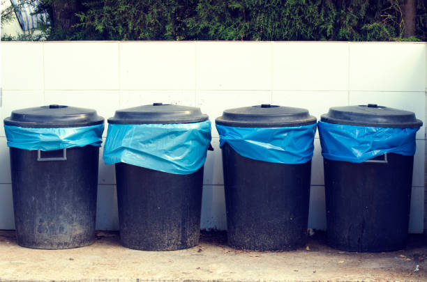 Four bins on the street with garbage bag