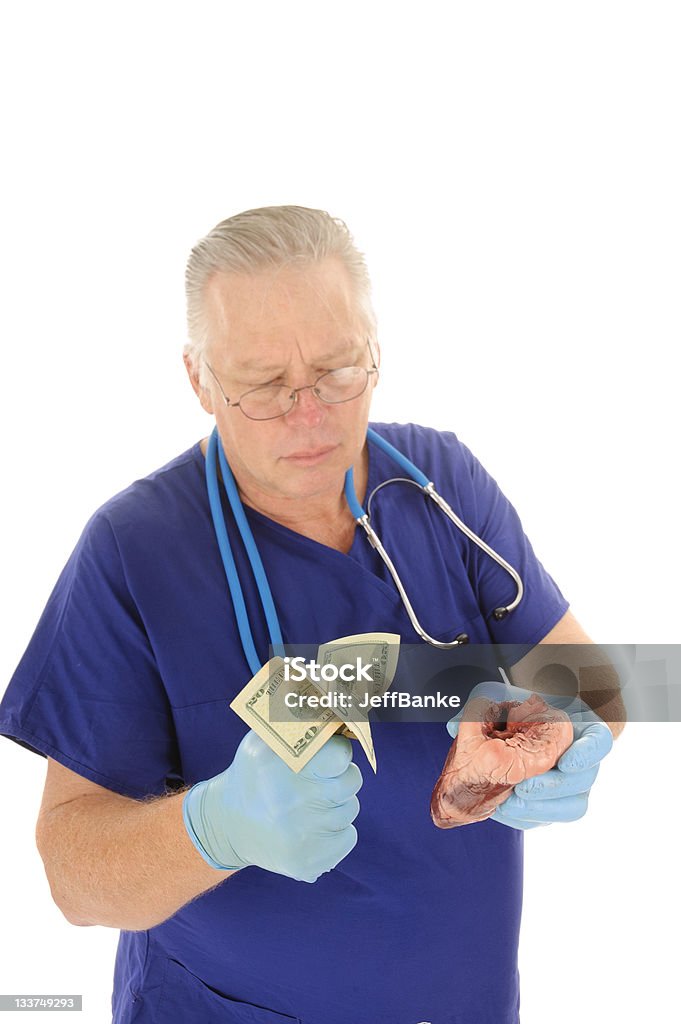 Surgeonwith puño lleno de dinero y un corazón - Foto de stock de Asistencia sanitaria y medicina libre de derechos