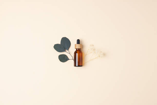 istock Cosmetic bottle with flowers and eucalyptus on pastel beige background. Flat lay, copy space 1337493642