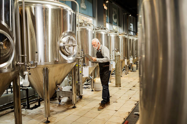 istock Mature Supervisor in Brewery checking quality of beer in flask 1337494411