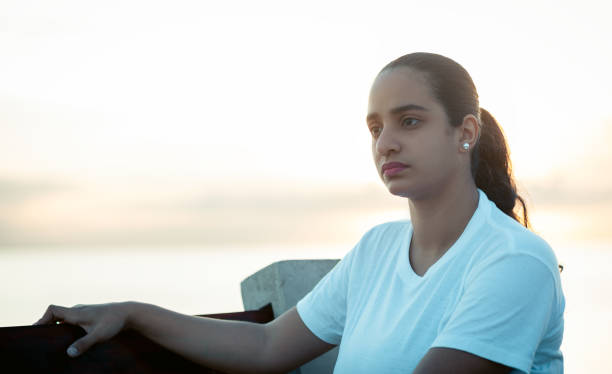 istock woman sitting on a bench thinking, while watching the sunrise 1337494930