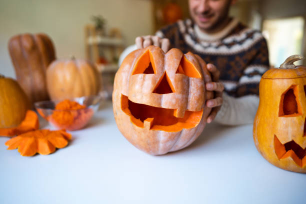 istock Unrecognizable man carving a pumpkin for Halloween at home 1337495675