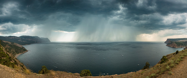 Heavy rain over the sea, bad weather, atmospheric phenomena. Panorama, view from the mountain