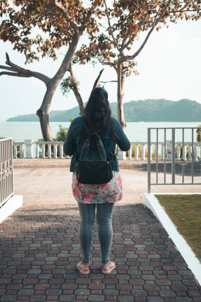 istock woman standing looking at the ocean 1337503324