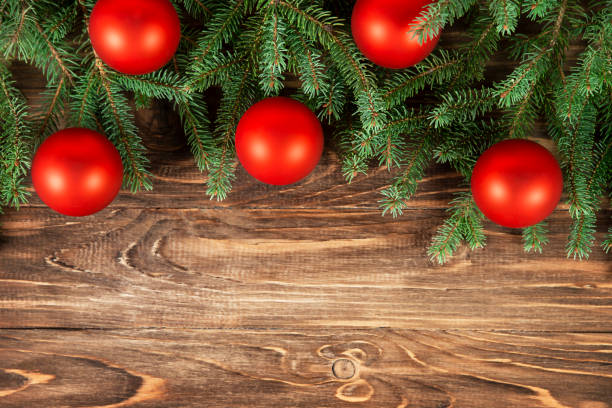 istock Fir branches are decorated with red balls on a wooden background. 1337503446