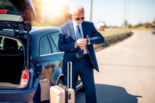 Senior businessman traveling to work wit car,having little break.