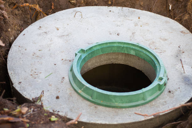 istock Construction of a septic tank. Large concrete rings embedded in the ground, from above an open sewer hatch, unprotected by a cover from falling 1337506071