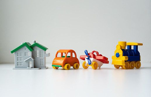 Closeup image of house, car, airplane and train figure models on the white background. Property and vehicle insurance