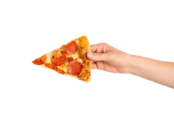 Slice of pepperoni pizza in hand isolated on white. Top view on paperoni pizza. Concept for italian food, street food, fast food, quick bite