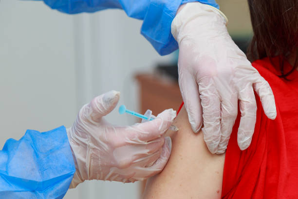 istock Syringe injection process on real coronavirus vaccination. Fighting the covid-19 pandemic. Selective focus , toned 1337508199