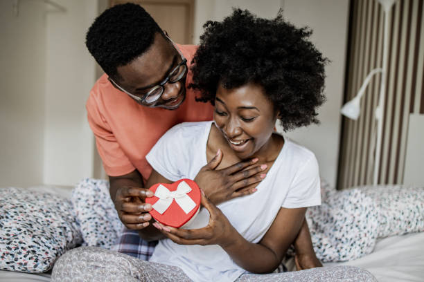istock Young man surprising his girlfriend with a love present in the morning 1337509509