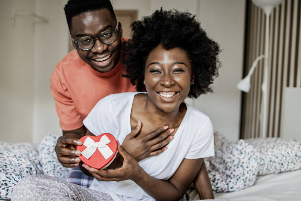 istock Young man surprising his girlfriend with a love present in the morning 1337509510