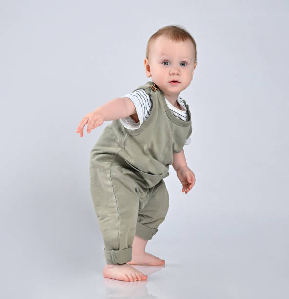 premiers pas de bébé isolé sur fond blanc - baby walking child standing photos et images de collection