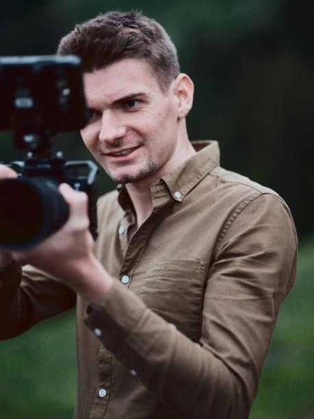 istock Portrait of young man using camera outdoors 1337511252