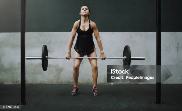Shot Of A Young Woman Exercising With A Barbell In A Gym Stock Photo - Download Image Now