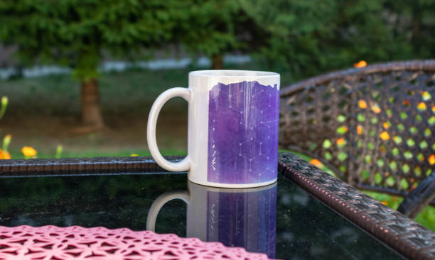 istock A purple coffee cup reflected on a black glass table in the garden 1337512311