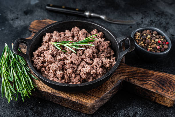 istock Fried mince beef meat in a pan for cooking pasta. Black background. Top view 1337512333