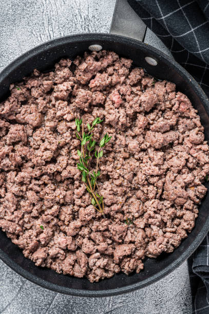 istock Fried mince beef and lamb meat in a pan with herbs. White background. Top view 1337512348