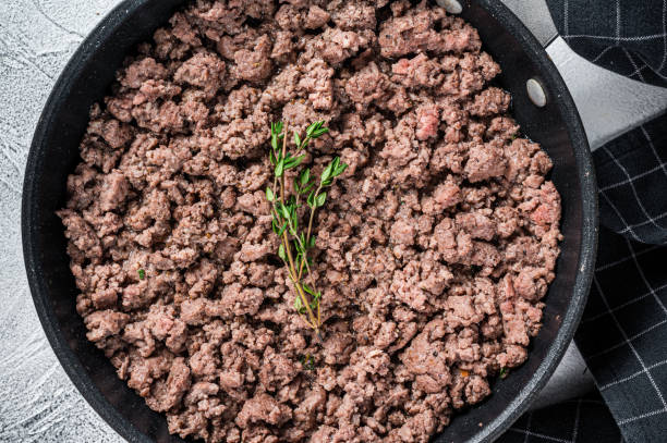 istock Fried ground mince beef and pork meat in a pan with herbs. White background. Top view 1337512380
