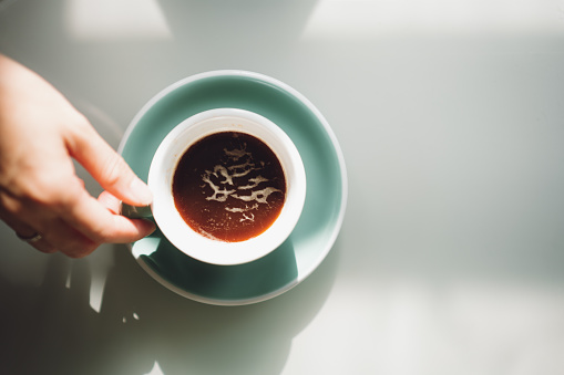 Directly Above Shot Of Hands Holding Coffee Cups On Table.