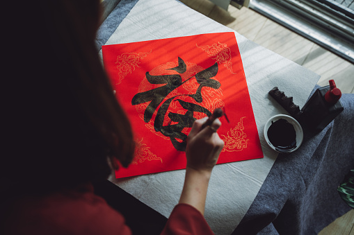 Asian woman writing the Chinese character \