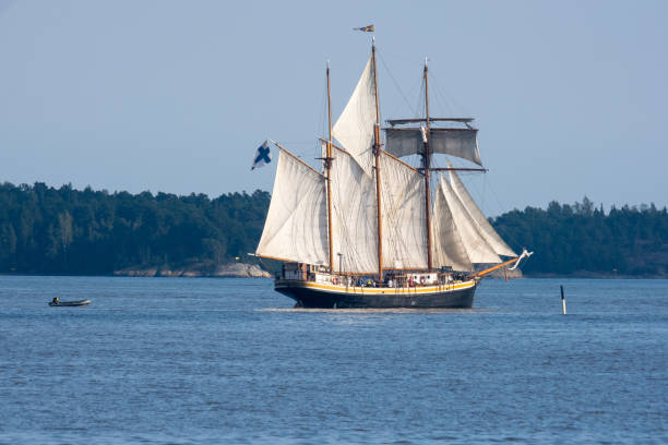 istock An old schooner with rised sails sailing across the horizon. 1337514099
