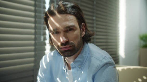 istock A young serious man is sitting on the sofa and looking away 1337518440