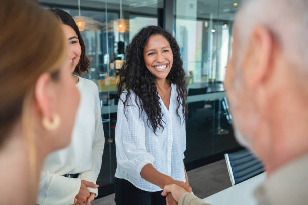 groupe de gens d’affaires se saluant en se serrant la main dans un bureau. - business relationship cooperation business handshake photos et images de collection