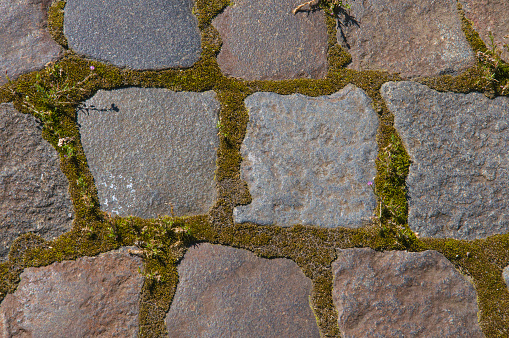 Texture of gray vintage natural urban paving stone close up