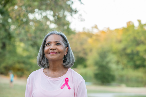 Hermosa mujer mayor sonríe mientras camina por la concientización sobre el cáncer de mama photo