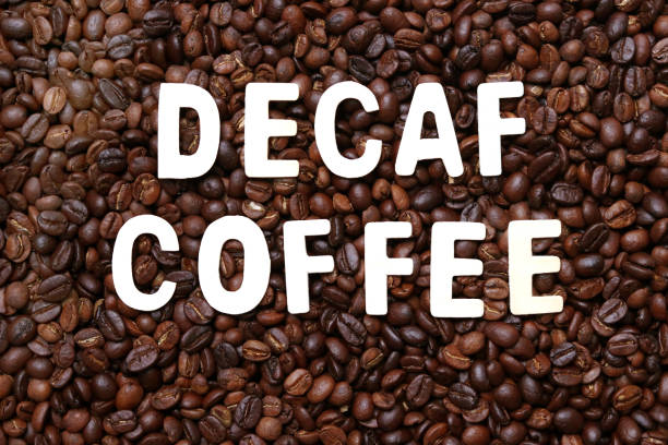 Decaf coffee word on roasted coffee beans background. Concept of decaffeinated coffee or low caffeine coffee. decaffeinated stock pictures, royalty-free photos & images